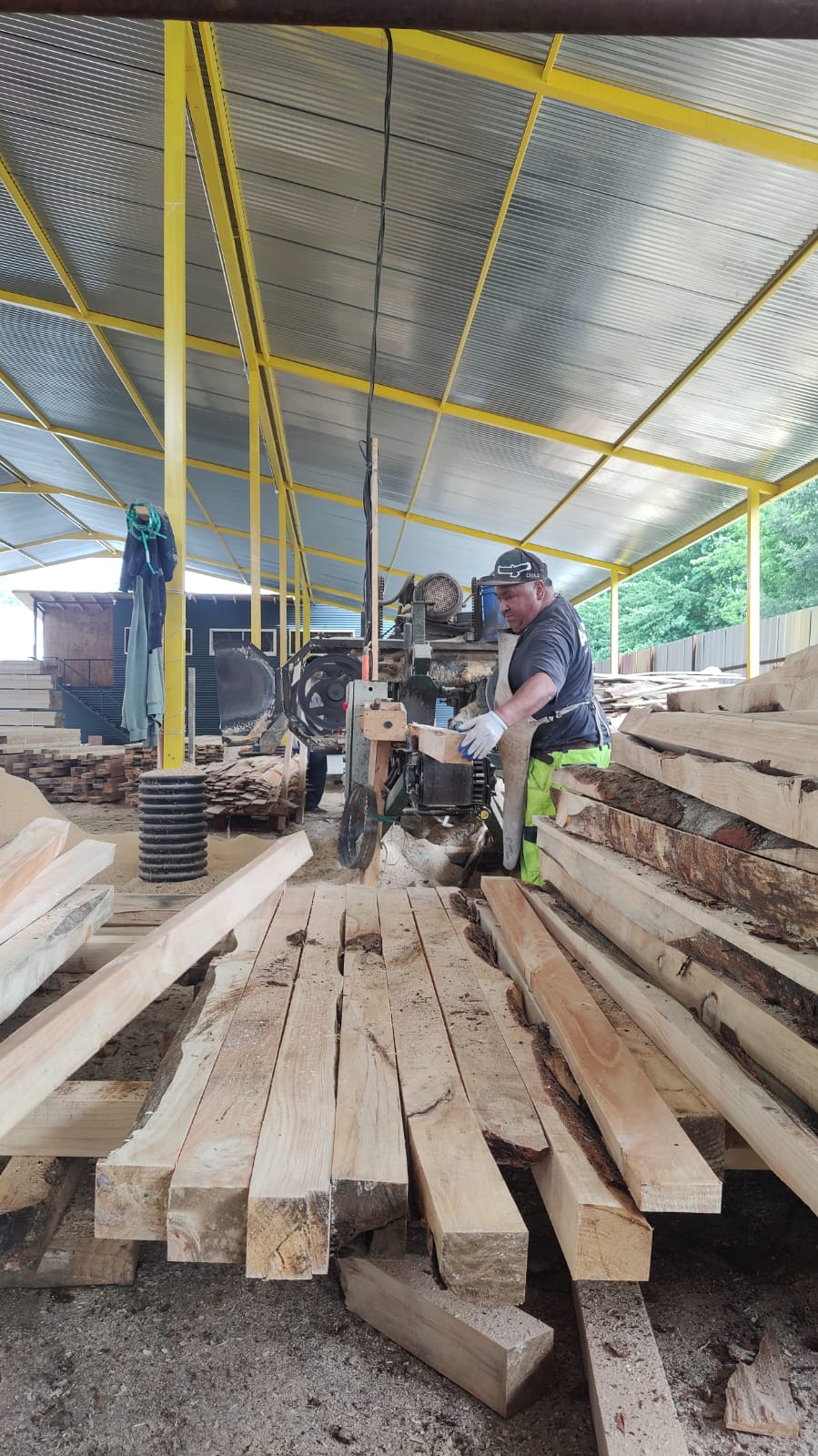 Persona cortando palos de madera para pallets